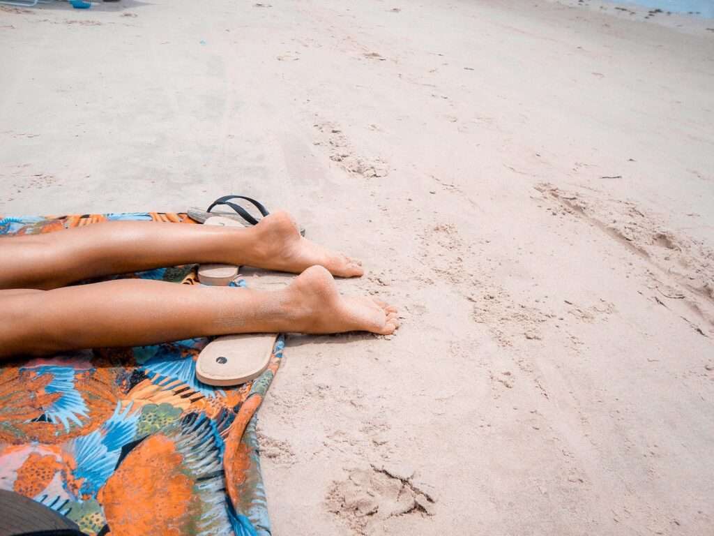 sunbather's feet on nude beach in brazil